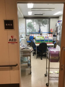 介護施設のスタッフルーム。AED設置、デスク作業スペース、窓からの採光。